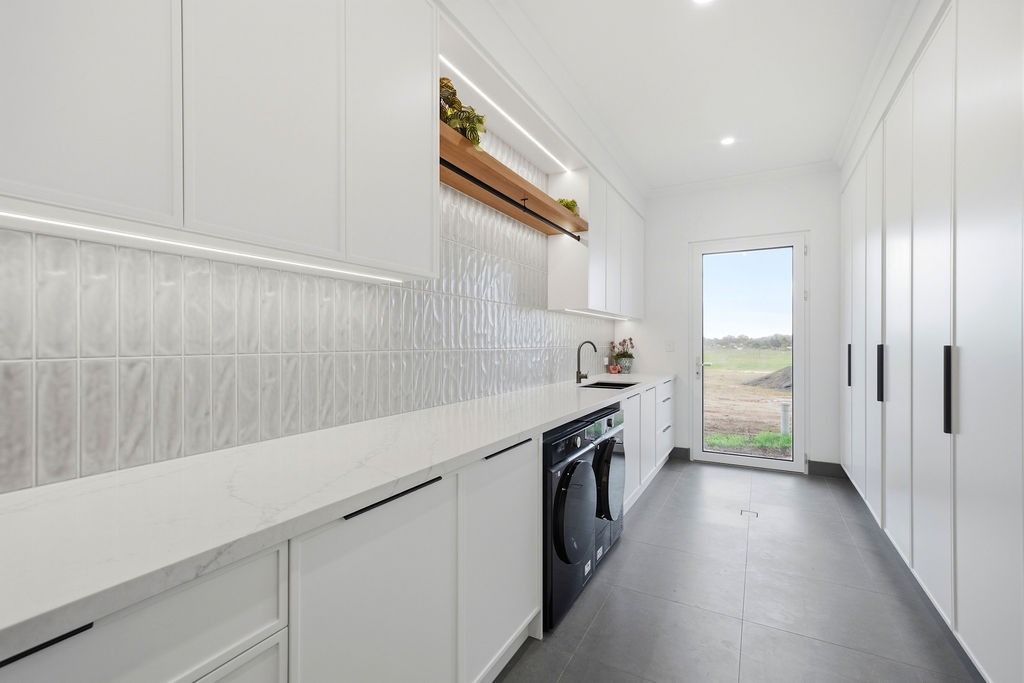 Laundry with textured tile splashback and country outlook
